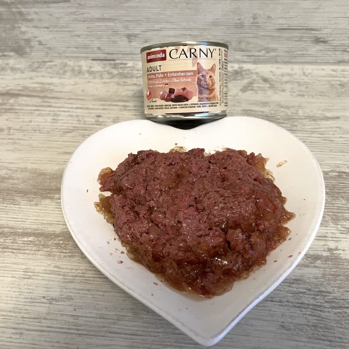 Animonda Carny Nassfutter auf einem Teller mit Dose im Hintergrund