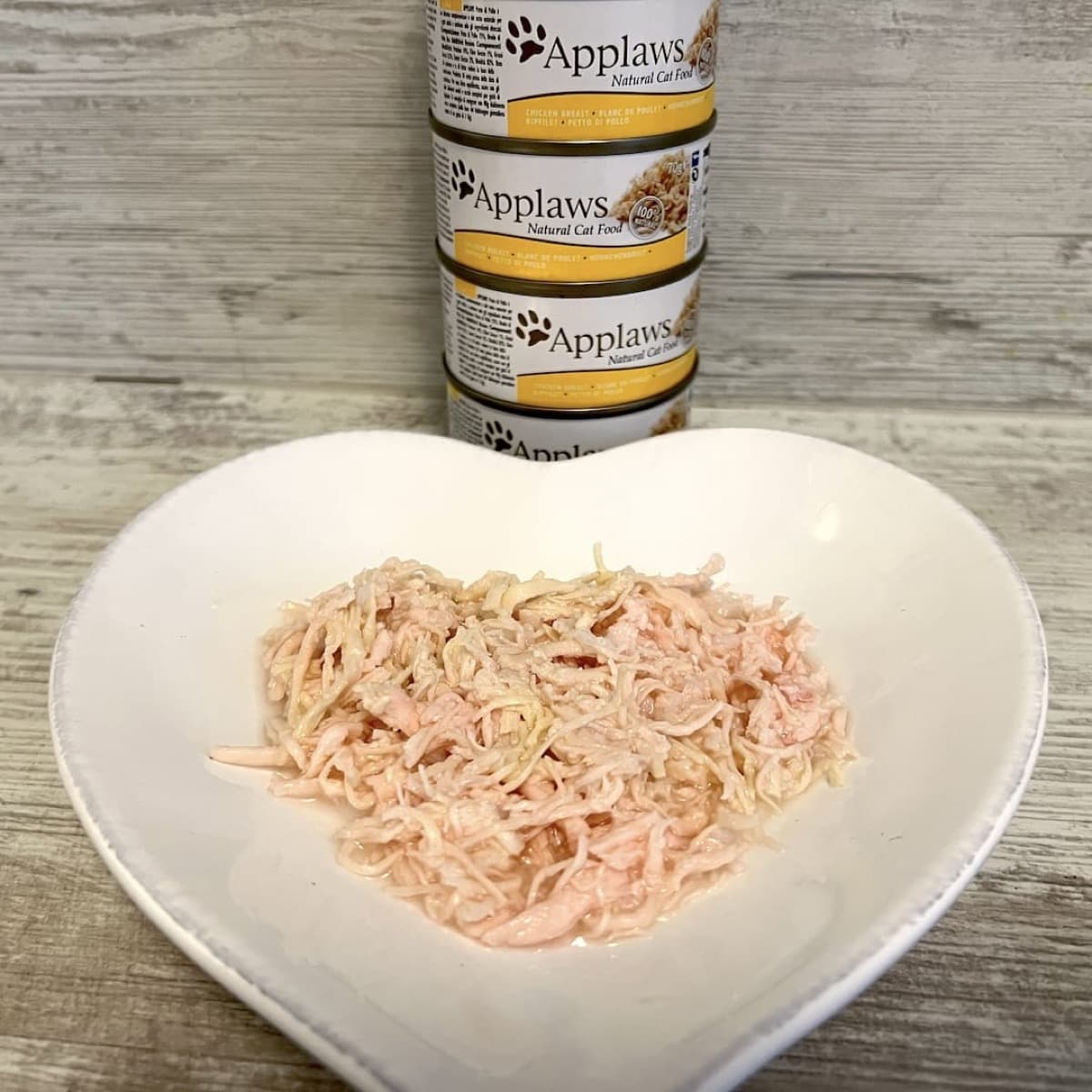 Applaws Natural Cat Food Dosen mit Hühnerfleisch auf einem herzförmigen Teller